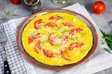Omelette with tomatoes, herbs and grated cheese. Easy breakfast
