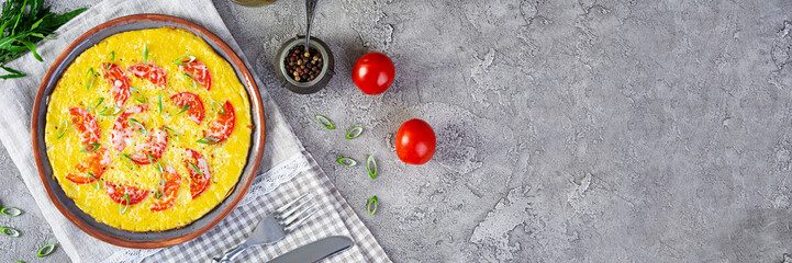Omelette with tomatoes, herbs and grated cheese. Easy breakfast