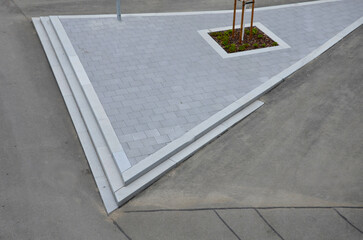 wide granite stone staircase looks representative. cobblestone tiles and metal longitudinal gutter...