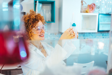 Shot of a female scientist working in a lab. Close-up of serious laboratory worker holding ampoule...