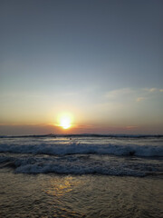 Sunset on the beach. Waves on the sea