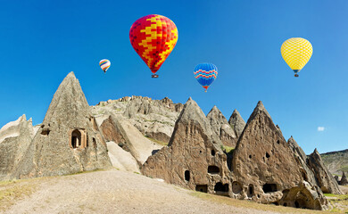 Colorful hot air balloons flying over volcanic cliffs at Cappado
