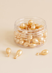 Face serum capsules in a jar on light yellow close up. Cosmetics, beauty product