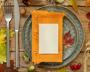 Autumn rustic table setting with place card and envelope between leaves and berries top view, mockup