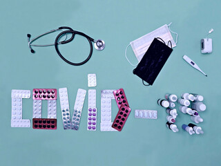 COVID-19, composition contained in blisters with pills and medicines for cough and runny nose on a turquoise background
