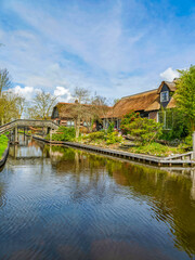 Obraz premium Thatched roof houses on canal bank in Giethoorn village, Netherlands