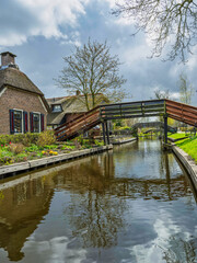 Fototapeta na wymiar Wooden bridges over Giethoorn canal on beautiful summer day, Netherlands