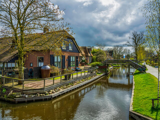 Obraz premium Canal side Dutch house and wodden bridge in the charming village of Giethoorn, Netherlands