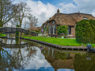 Fototapeta na wymiar Traditional Giethoorn houses on the canal with wooden bridges, Netherlands