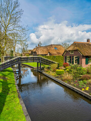 Fototapeta na wymiar Thatched roof houses house on canal side in the charming village of Giethoorn, Netherlands