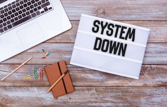System Down message in lightbox on office desk flat lay