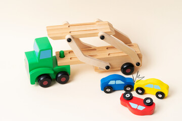 Toy tow truck towing damaged cars after a serious accident. Car traffic, car crash, dangerous incident.