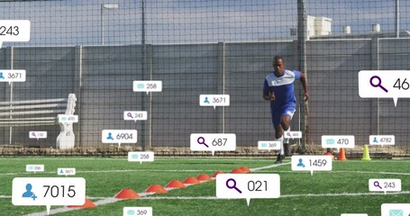Animation of social media icons over african american male soccer player training on sports field - Powered by Adobe
