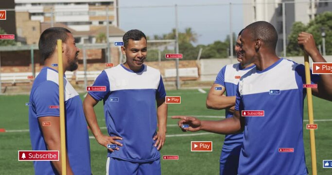 Animation of social media icons over team of diverse male soccer players discussing on sports field - Powered by Adobe