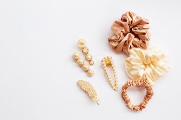 Collection of trendy silk elastic band scrunchies and pearl hair clips on white background. Diy...