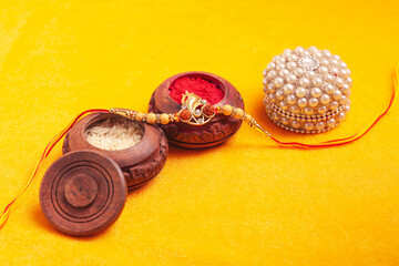 Indian festival: Raksha Bandhan. A traditional Indian wrist band on yellow background.