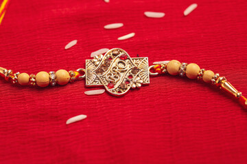 Indian festival: Raksha Bandhan. A traditional Indian wrist band on red background.