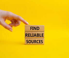 Find reliable sources symbol. Wooden blocks with words Find reliable sources. Beautiful yellow background. Businessman hand. Business and Find reliable sources concept. Copy space.