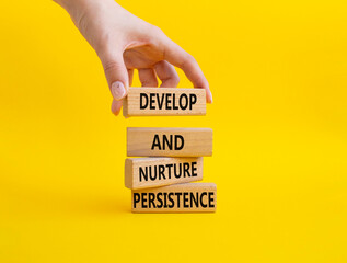 Persistence and development symbol. Wooden blocks with words 'Develop and nurture persistence'. Beautiful yellow background. Businessman hand. Business concept. Copy space.