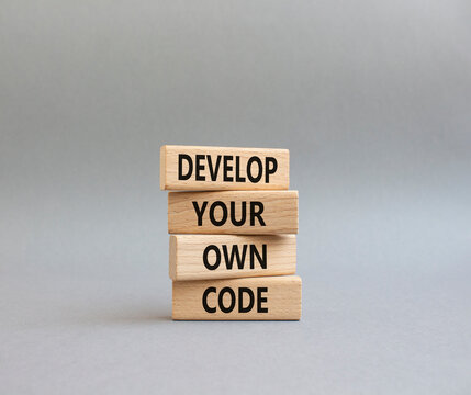Develop your own code symbol. Concept words Develop your own code on wooden blocks. Beautiful grey background. Business and Develop your own code concept. Copy space.
