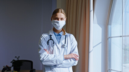 Fototapeta na wymiar Concept of Coronavirus doctor woman with a protective mask looking straight to the camera and have a sad and tired face