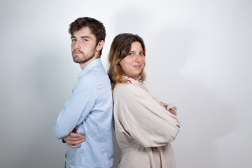 portrait d'un jeune couple de 25 ans dos à dos souriant et regardant la caméra. Isolé sur fond...