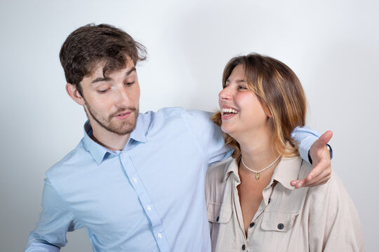 un couple s'amuse et plaisante. La jeune femme chatouille son compagnon en riant.