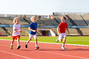 Fototapeta na wymiar Child running in stadium. Kids run. Healthy sport.