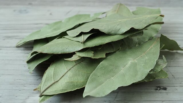Dried whole bay leaves on cutting board (Laurus nobilis)