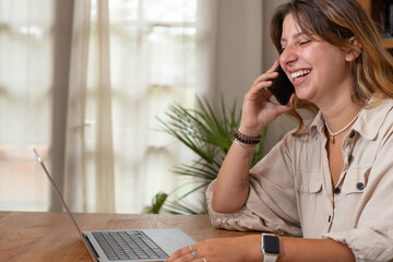 Jolie jeune femme employée de bureau qui travaille à la maison avec un ordinateur portable. Elle...