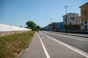 Naklejka premium city: road, sidewalk and cycle path in perspective. mono skate in the distance on the bike path. Prediferic urban area, white line of roadways, guides the perspective to infinity.
