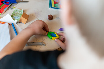 Fototapeta premium Poland, Krakow – April 03, 2022: Child is sculpting a figure from plasticine at the table