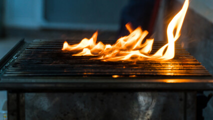 Blurred photo of fire on the barbecue. Close-up of fire view. Blurred motion and noise included