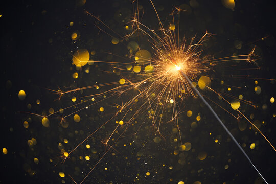 Happy New Year, Sparkler burning bright with shiny sparks and bokeh festive silvester party background