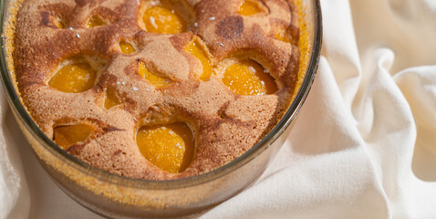 Close-up of Tasty peach pie on white textile background. Top view.