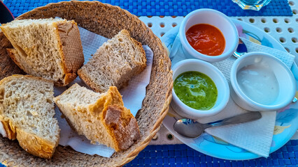Sauces called Mojo rojo and mojo verde served with white bread in a local restaurant in Los Abrigos, Tenerife, Canary Islands, Spain, Europe, EU. Local traditional food. Appetiser