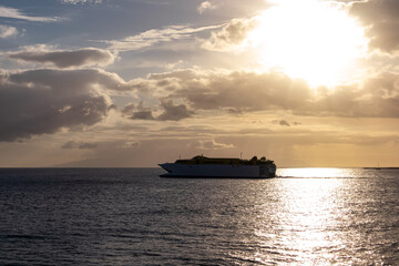 Obraz premium Romantic sunset seen from lookout Cypelek Los Cristianos, Tenerife, Canary Islands, Spain, Europe. Silhouette of regular ferry boat leaving from the harbour towards Island of La Gomera. Island hopping
