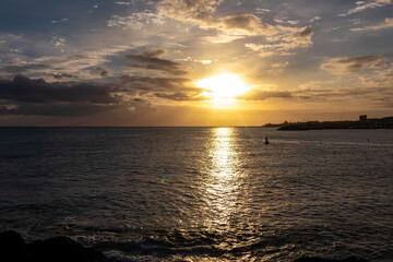 Romantic sunset over the sea in summer seen from lookout Cypelek Los Cristianos, Tenerife, Canary Islands, Spain, Europe. Vibrant colours of the clouds. Vacation vibes on the Atlantic Ocean. Awe