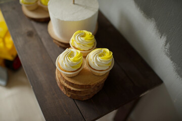 Cupcakes with white and yellow cream on a wooden stand