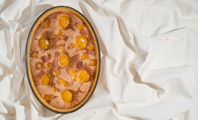 Tasty peach pie on white textile background. Top view.
