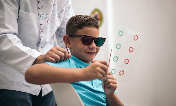 A child is subjected to some convergence-divergence cards with red and green glasses.vision therapy.