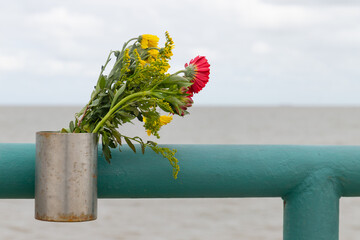 flowers in a box from survivors on a memorial place for deceased persons buried at sea
