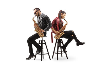 Modern young male and female musicians sitting back to back and playing sax