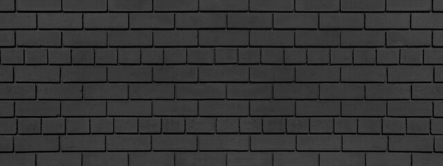 Old dark grey brick wall wide texture. Black exterior brickwork grunge background