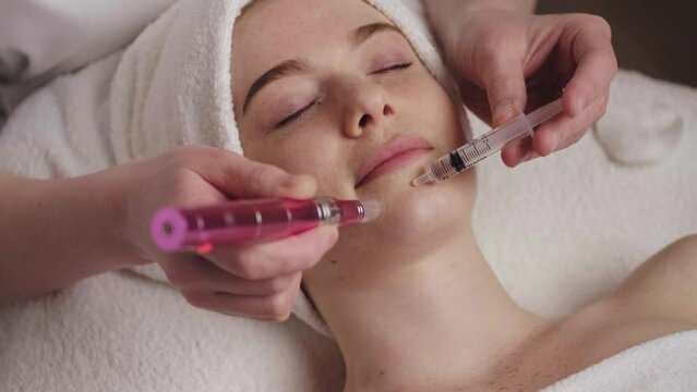Beautician makes the procedure Microdermabrasion on the woman's face in a beauty salon. Facial treatment. Medical treatment. Beauty treatment. Aesthetic