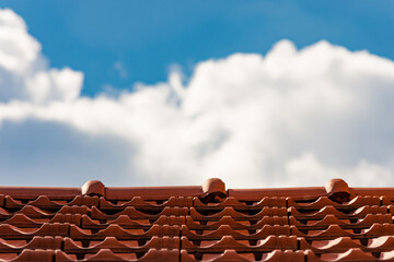 Close up to ceramic roof tiles and a cloudy sky in background