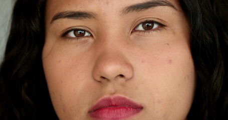 Casual hispanic girl face close-up looking at camera. Serious Latina teen