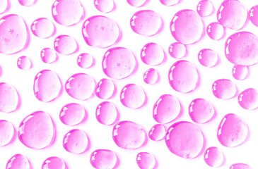 The texture of a liquid transparent gel for facial cleansing. Oil serum sample with bubbles on a pink background. Moisturizing cosmetic product for skin care. Lotion for dry skin. Beauty concept