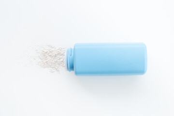 Talcum powder in container. Spilled white powder