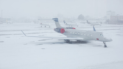 Snow covered commercial plane at the airport. Close-up of the plane after snowfall. Winter bad...